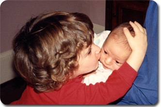 Julie gently kissing baby Andrew