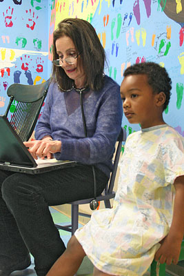 Dr. Carol Herrmann entering health data for Cherub sitting next to her