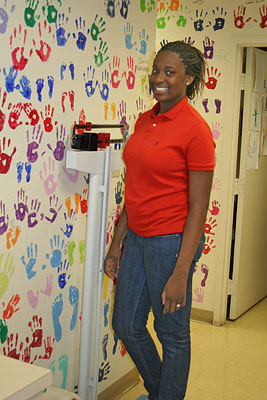 teenager in red shirt standing on the scale and smiling