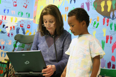 Dr. Carol Herrmann and Cherub looking at computer