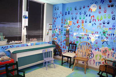 colorful room with chairs and blue walls painted with hand and foot prints