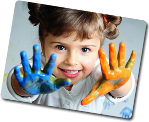 young girl holding up hands covered with fingerpaint