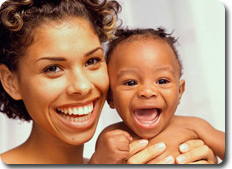 smiling Mom holding baby expressing joy and delight